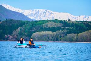 two people sitting on a boat in the water at Hakuba Gateway Hotel in Hakuba