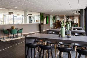 a restaurant with two tables and chairs and a bar at Scandic Lerkendal in Trondheim