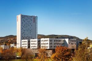 a tall white building with trees in front of it at Scandic Lerkendal in Trondheim