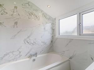 a white bathroom with a tub and a window at 3 Bed in Harrogate oc-93305 in Summer Bridge