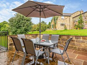 a table and chairs with an umbrella on a patio at 3 Bed in Harrogate oc-93305 in Summer Bridge