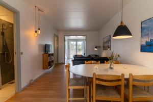 a dining room and living room with a table and chairs at Feriecenter Slettestrand in Fjerritslev