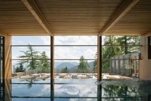 a house with a pool with a view of the mountains at Vigilius Mountain Resort in Lana