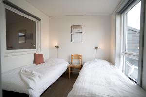 two beds in a room with a window at Feriecenter Slettestrand in Fjerritslev +84 photos