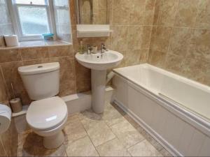 a bathroom with a toilet and a sink and a bath tub at Bumblebee Cottage, Aysgarth Falls in Aysgarth