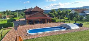a swimming pool in a yard next to a house at Villa Rózsa Vendégház in Erdőbénye