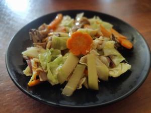 a black plate of food with vegetables on a table at Beatus Residence San Isidro in New Agutaya +31 photos