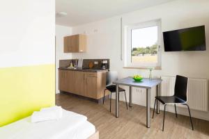 a room with a kitchen and a table and chairs at Green Guest House in Wörth an der Isar