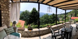 a patio with a table and chairs and a large window at ΤΟ ΑΡΧΟΝΤΙΚΟ in Kríkellon