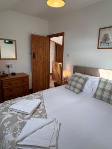 a bedroom with a large bed with towels on it at Upper Grippath Farm Holiday Cottages in Newport