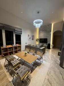 a living room with a table and chairs and a couch at Baby Blue pool villa in Ban Bo Prakhon