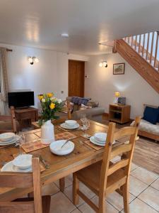 a living room with a wooden table and chairs at Upper Grippath Farm Holiday Cottages in Newport