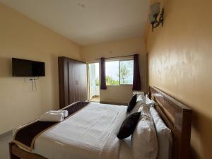 a bedroom with a large bed with a window at kollanoor guest house in Madikeri