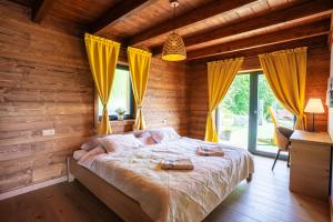 a bedroom with a large bed with yellow curtains at Chalet George in Zázrivá