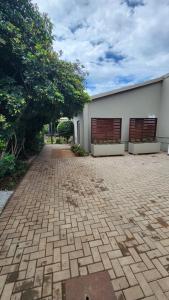 a brick driveway in front of a white building at 14 on Maroela in Polokwane