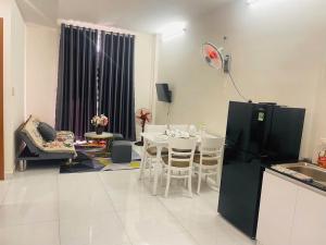a kitchen and living room with a table and a refrigerator at Coral Homestay Phan Rang in Kinh Dinh +13 photos
