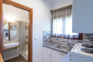 a bathroom with a sink and a mirror and a sink at Olga Villa in Megali Ammos +37 photos