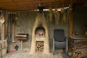 a kitchen with an oven with a pile of wood at Cosy farmhouse with sauna in Sint-Truiden