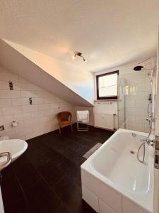 a bathroom with a white tub and a sink at Oberkasseler Hof Bonn in Bonn