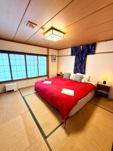 a bedroom with a large red bed in a room with windows at Edo-Ko House in Myoko