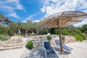 a patio with two chairs and an umbrella at House Sage in Tkon
