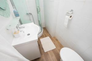 a white bathroom with a toilet and a sink at House Sage in Tkon +27 photos