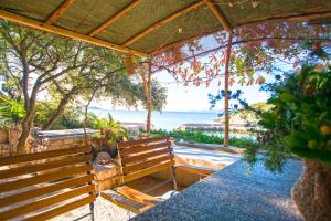 a wooden bench sitting in front of the beach at House Sarah in Tkon