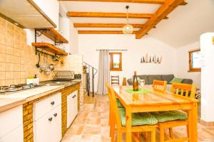 a kitchen and dining room with a wooden table and chairs at House Sarah in Tkon