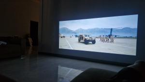 a large screen with a picture of a plane on a runway at NaklangHillHouse in Ko Lanta Yai