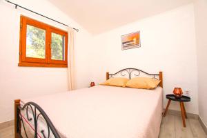 a bedroom with a white bed and a window at House Sarah in Tkon