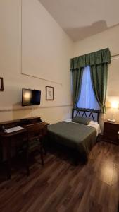 a bedroom with a bed and a desk with a computer at Hotel del Centro in Palermo +52 photos
