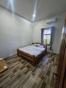 a bedroom with a bed and a window at NaklangHillHouse in Ko Lanta Yai