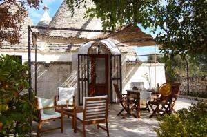 a patio with chairs and a table and a gazebo at Trullo Dei Fiori in Cisternino