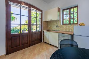 a kitchen with white appliances and a door with windows at Apartments Ivan in Kampor
