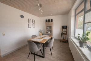 a dining room with a wooden table and chairs at Charmante FeWo in Dorflage in Ebersdorf