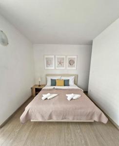 a bedroom with a large bed with two towels on it at Bella Vista Blu apartman s pogledom na more, Povljana, otok Pag in Povljana +17 photos