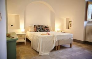a bedroom with a bed and a table in it at Trullo Dei Fiori in Cisternino