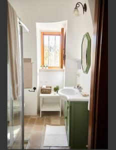 a bathroom with a sink and a mirror at Trullo Dei Fiori in Cisternino +29 photos