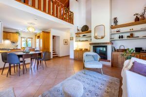 a kitchen and living room with a table and chairs at Quintinha Mojud in Rogil +24 photos