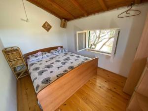 a small bedroom with a bed and a window at House Kornati Robinzon in Sit +17 photos