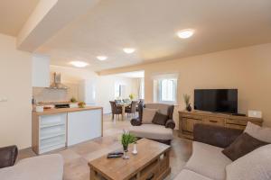 a living room with a couch and a tv at House Sandra in Lumbarda