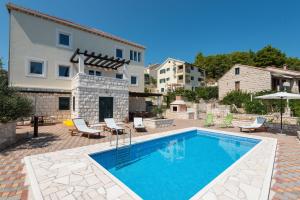 a swimming pool in front of a house at House Sandra in Lumbarda