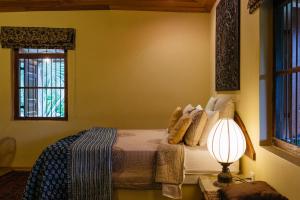 a bedroom with a bed with a lamp and a window at Villa Vista Haldummulla in Haputale