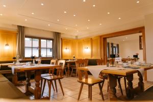 a dining room with wooden tables and chairs at ALPENHOF Westerbuchberg in Übersee
