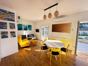 a living room with a table and yellow chairs at House Pavicic in Poljica