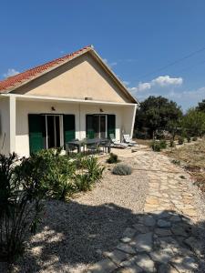 a house with a table and chairs in front of it at House Pavicic in Poljica