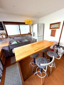 a kitchen with a wooden counter and two stools at Edo-Ko House in Myoko