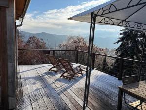 a patio with two chairs and an umbrella on a deck at Csillagfény Házikó in Nagymaros +7 photos