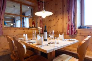 ein Esszimmer mit einem Tisch und Weingläsern in der Unterkunft Zischgalm in Obereggen