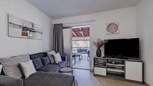 a living room with a couch and a flat screen tv at Villa Naty with Whirlpool by Villas Guide in Vela Luka